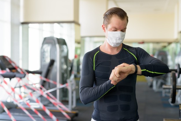 Young Man With Mask For Protection From Coronavirus Outbreak Checking Smartwatch At Gym During Coronavirus Covid 19 251136 24115