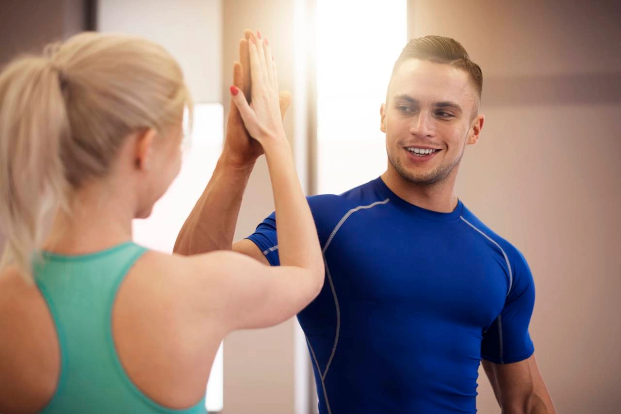 Спортивные мужчина и женщина дают друг другу пять