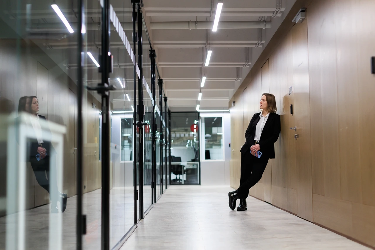 Ирина Кривошей в костюме прислонилась плечом к стене