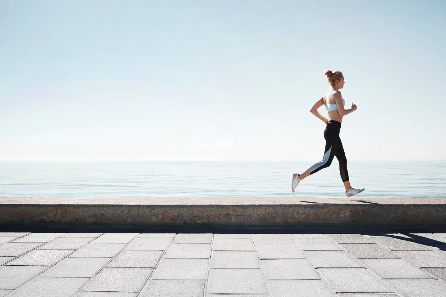 Спортсменка совершает пробежку по набережной