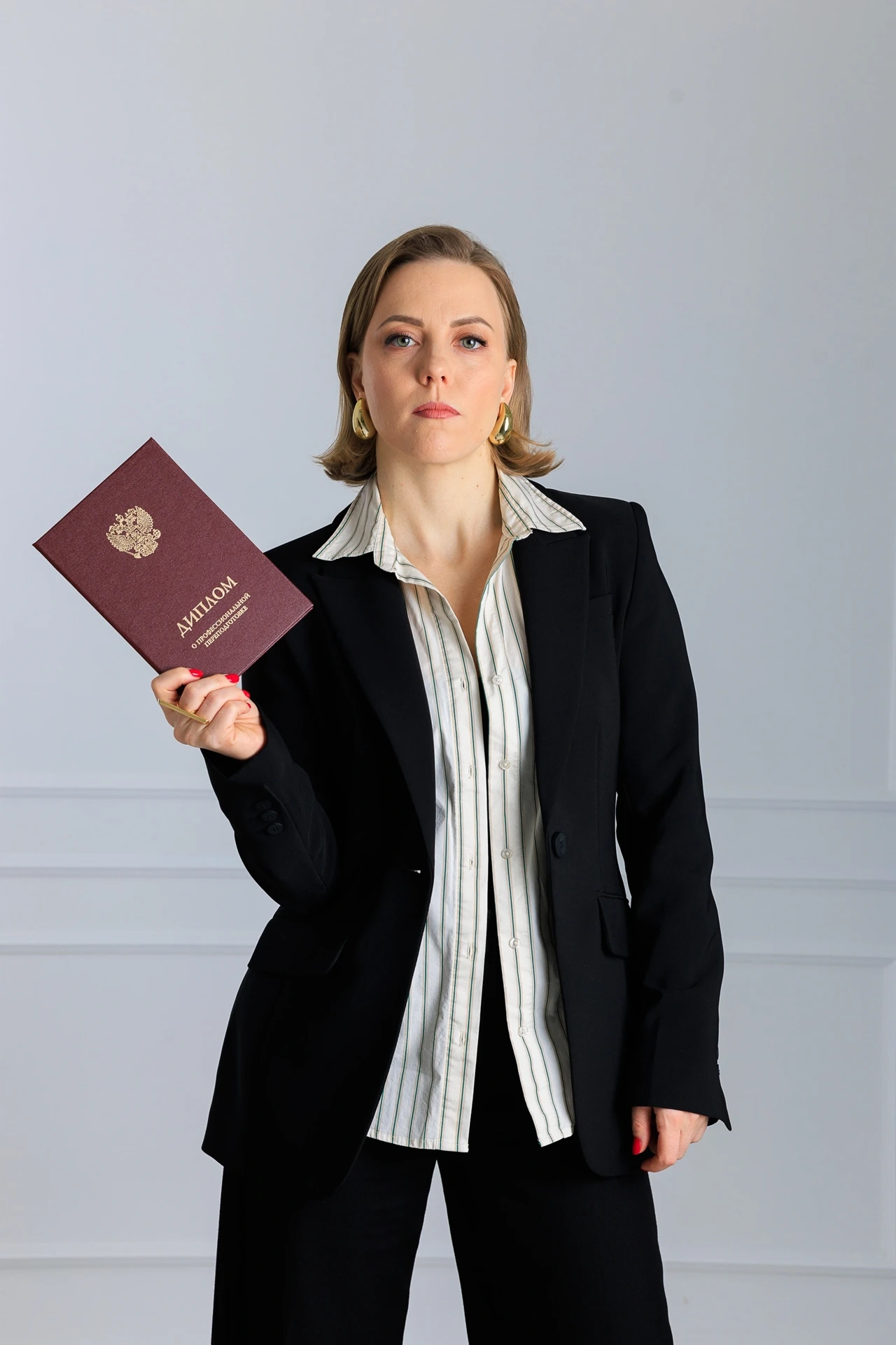 Ирина Кривошей в костюме держит красный диплом