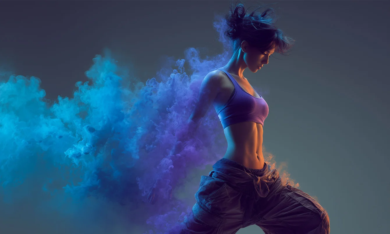 Танцовщица в динамичной позе на фоне яркого студийного освещения