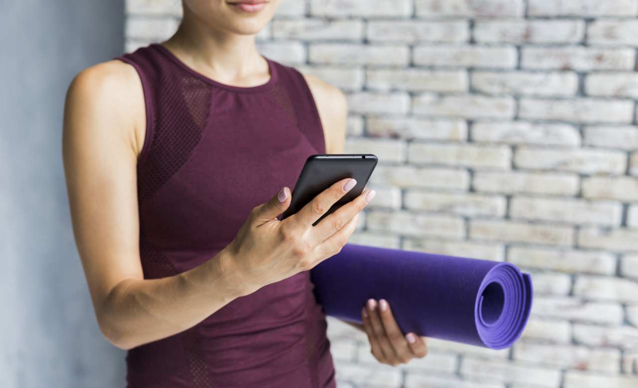 2 Woman Carrying Yoga Mat While Looking Her Phone