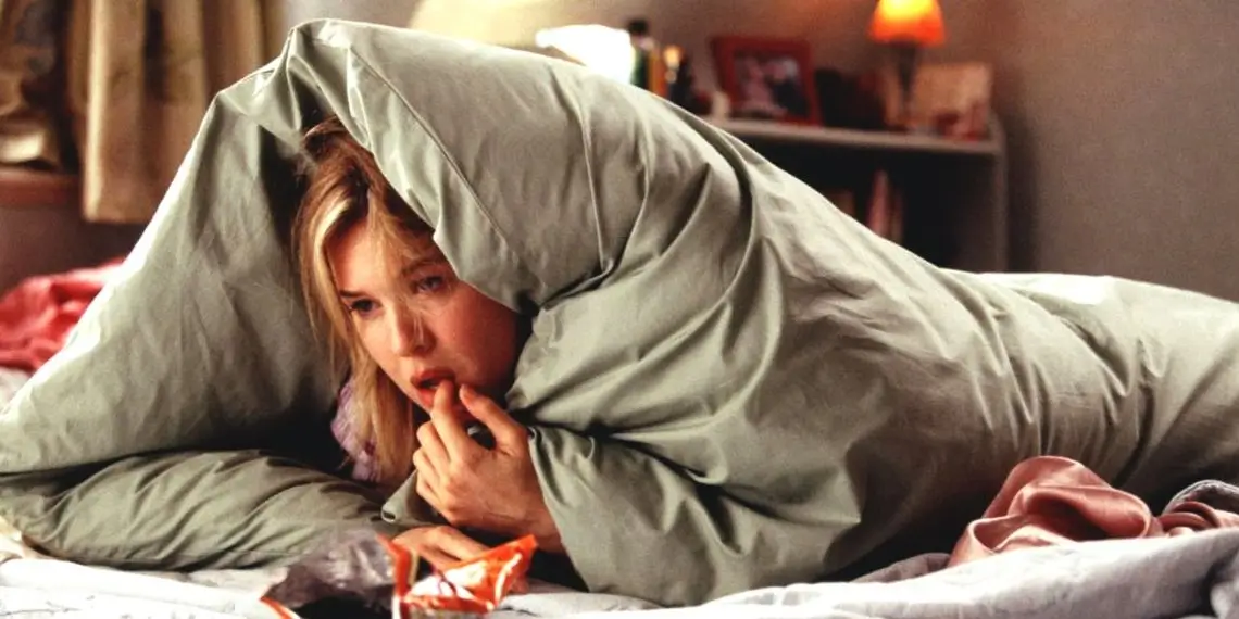 Бриджит Джонс ест в пижаме под одеялом